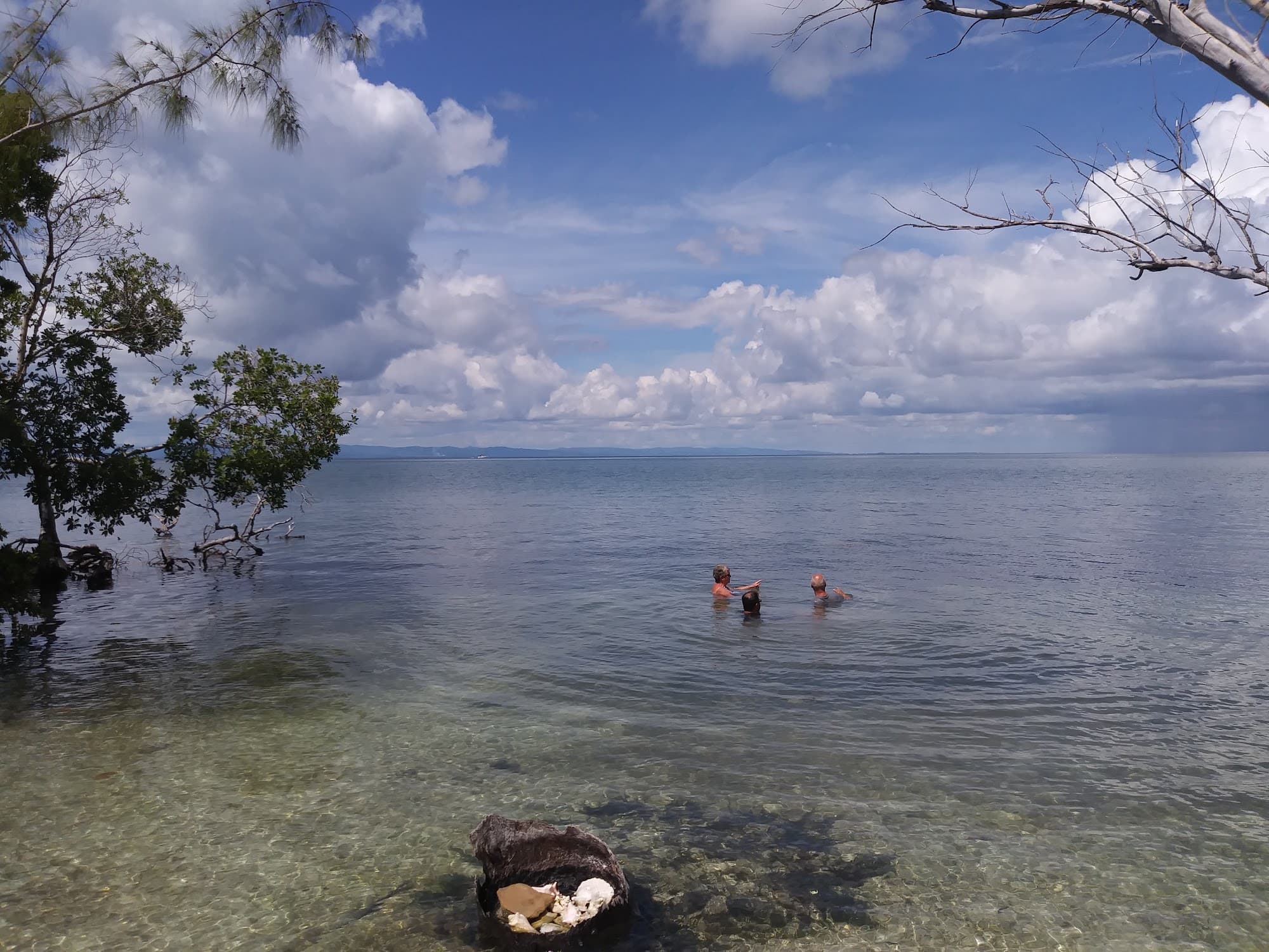 Guests wading in clear shallow water at Hawk Caye Lodge